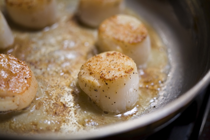 Scallops frying in pan